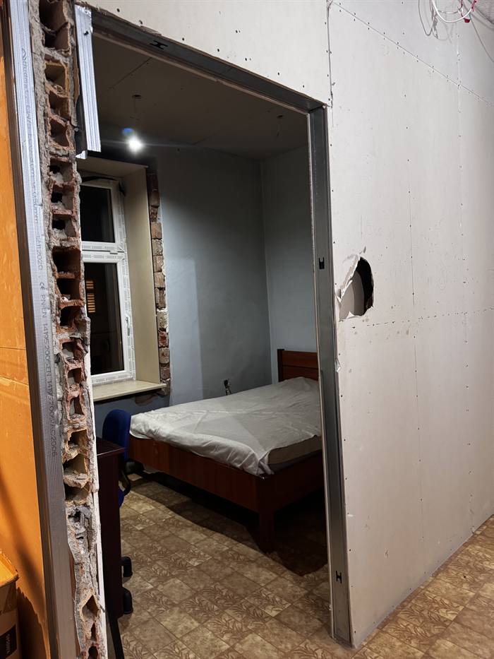 Pokój z odsłoniętą cegłą przy oknie – prace remontowe w toku